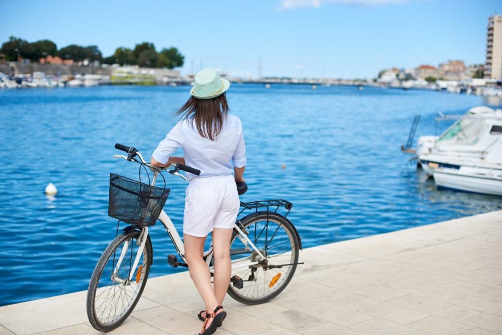 Deux vélos stationnés près d’un ferry dans un port des Cyclades, avec les maisons blanches en arrière-plan.