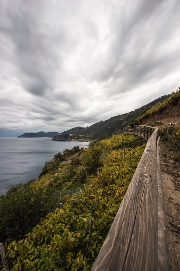 Sentier côtier des Cinque Terre sous la pluie en novembre, avec les villages colorés en arrière-plan.