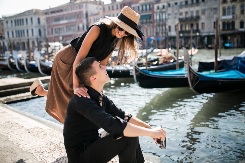 Couple assis sur un vaporetto à Venise, admirant les palais qui bordent le Grand Canal.